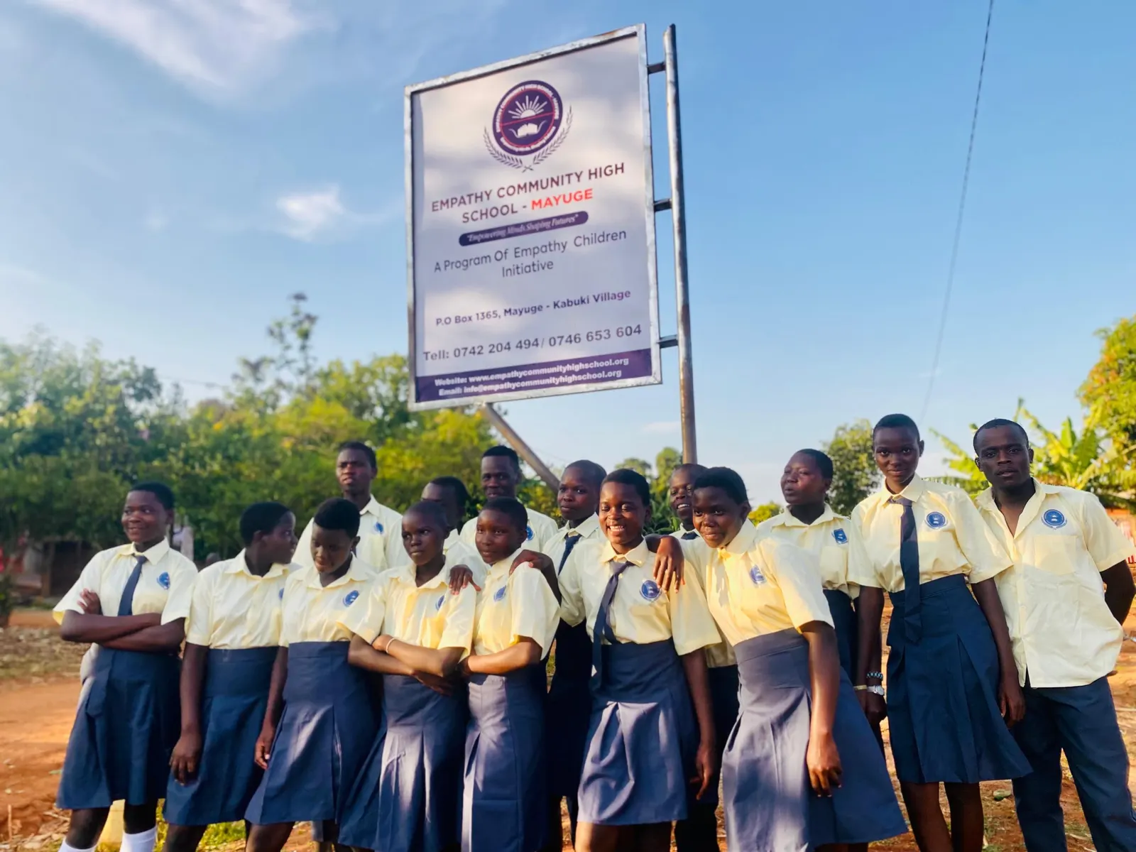 Students gathered in front of the Empathy Community High School signboard
